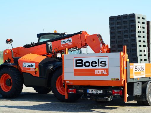 Telehandler moving equipment at a logistics site